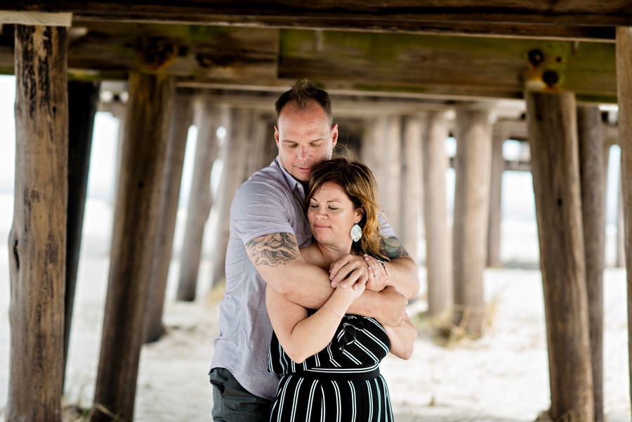 A man holds his fiance on the beach in their Cape May Engagement Session.